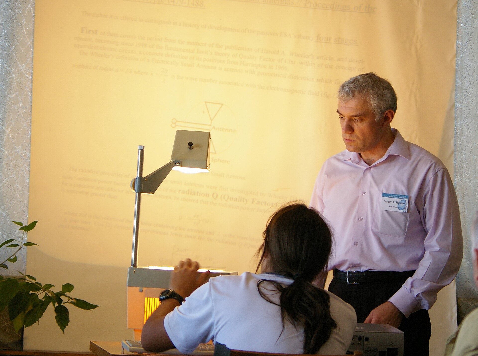 An overhead transparency projector with its Fresnel lens stage and projection arm.