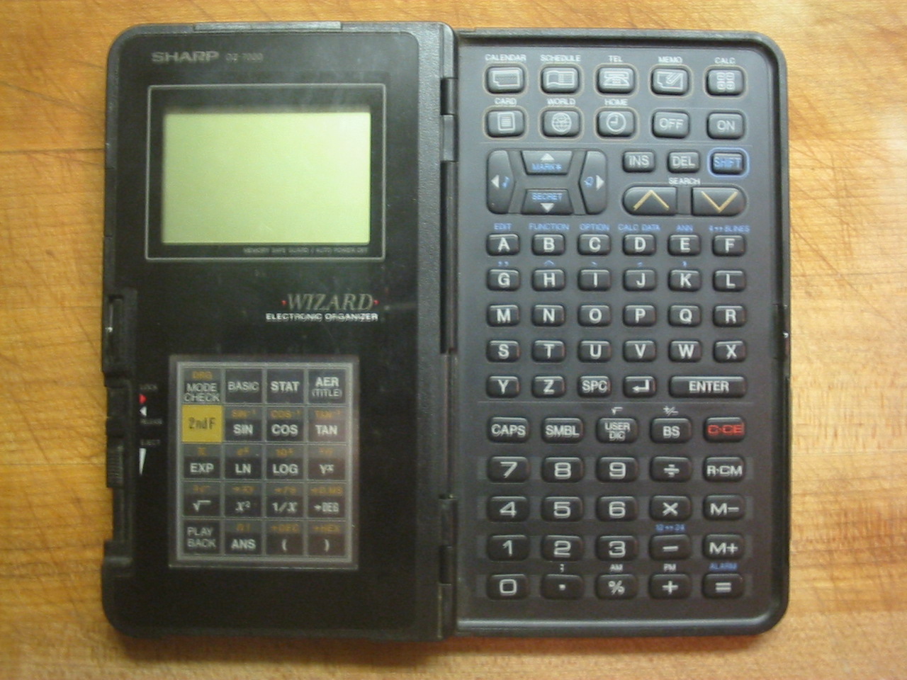 Sharp Wizard OZ-7000 electronic organizer open, showing the keypad and expansion card
