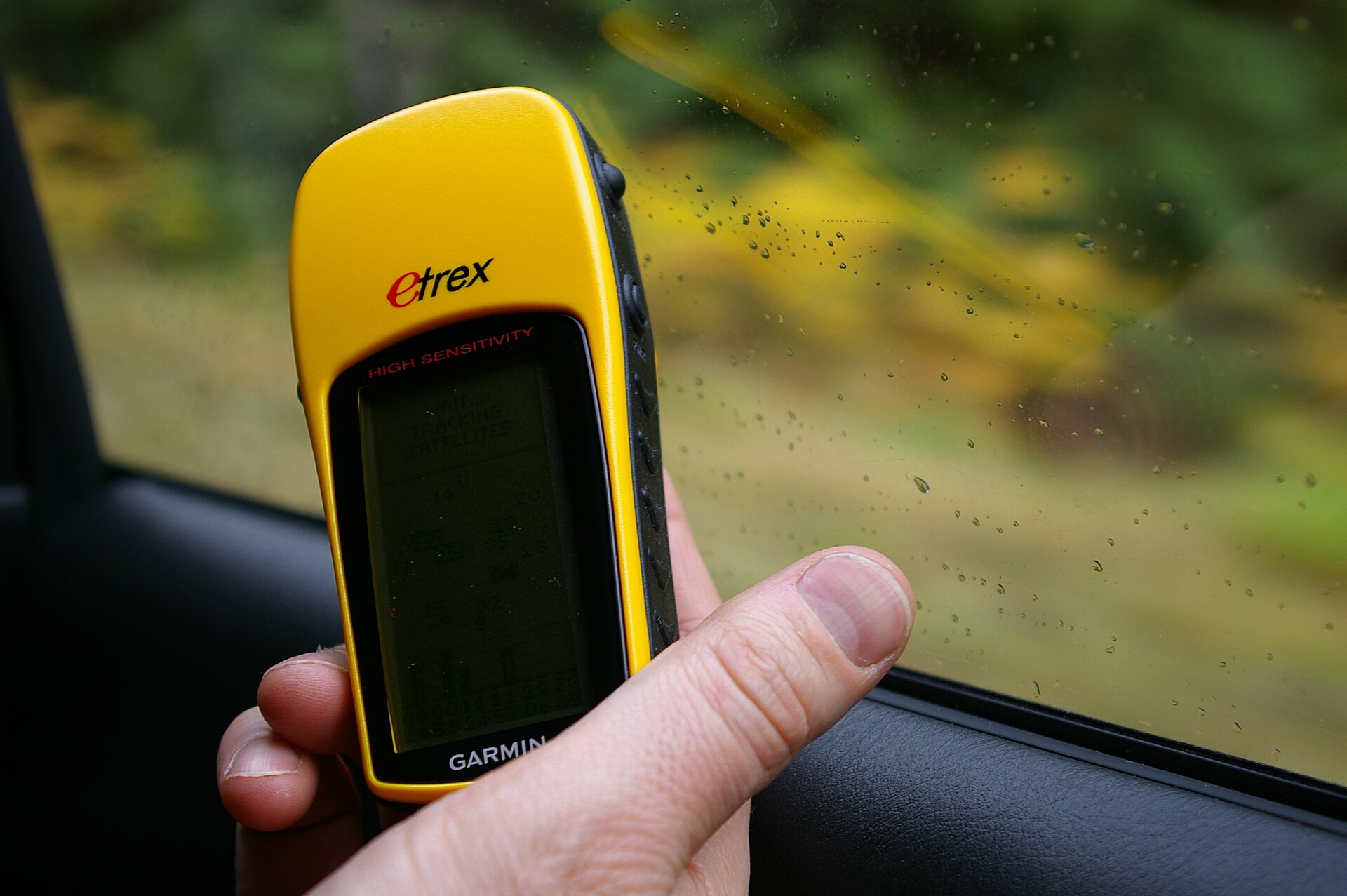 A Garmin eTrex H handheld GPS navigation unit, a compact yellow-and-grey portable device.
