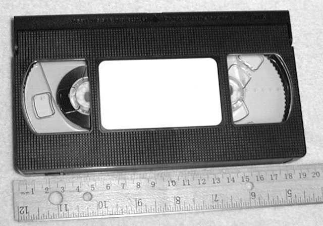 A VHS cassette shown with a ruler for scale