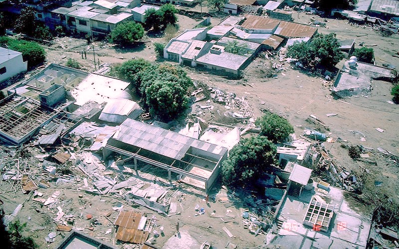 A December 1985 aerial view of Armero, Colombia: a few buildings standing amid the grey mud that buried the town.